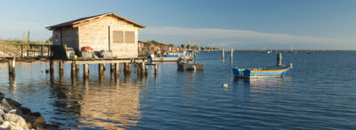 fishing huts and boats at scardovari lagoon, rovigo, italy