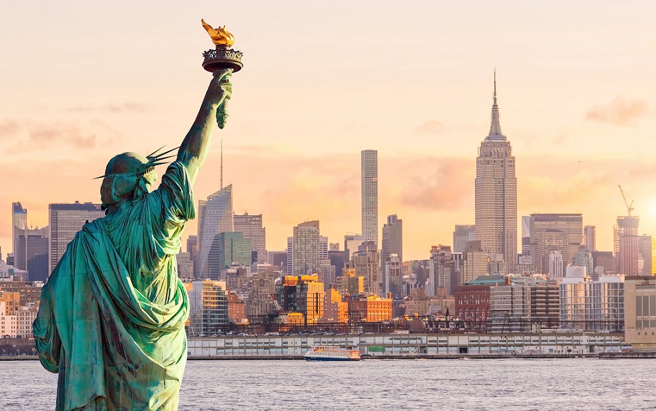 statue liberty and new york city skyline at sunset
