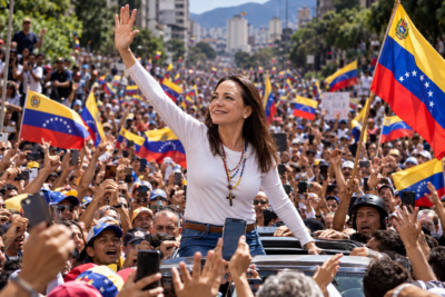 mujer saludando entre banderas venezolanas